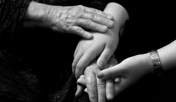 a black and white photo of two people holding hands