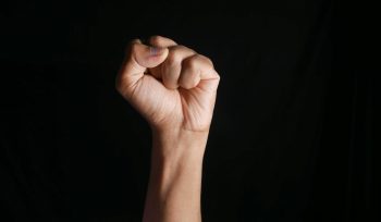 persons right hand doing fist gesture
