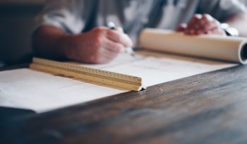 person drafting on blueprint