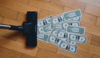 a pile of money sitting on top of a wooden floor