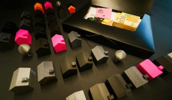 Miniature houses arranged with cash in an open box.