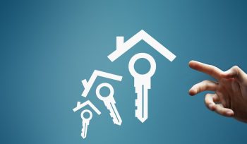 Hand reaching for house and key icons on blue background