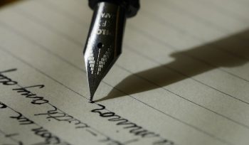 fountain pen on black lined paper