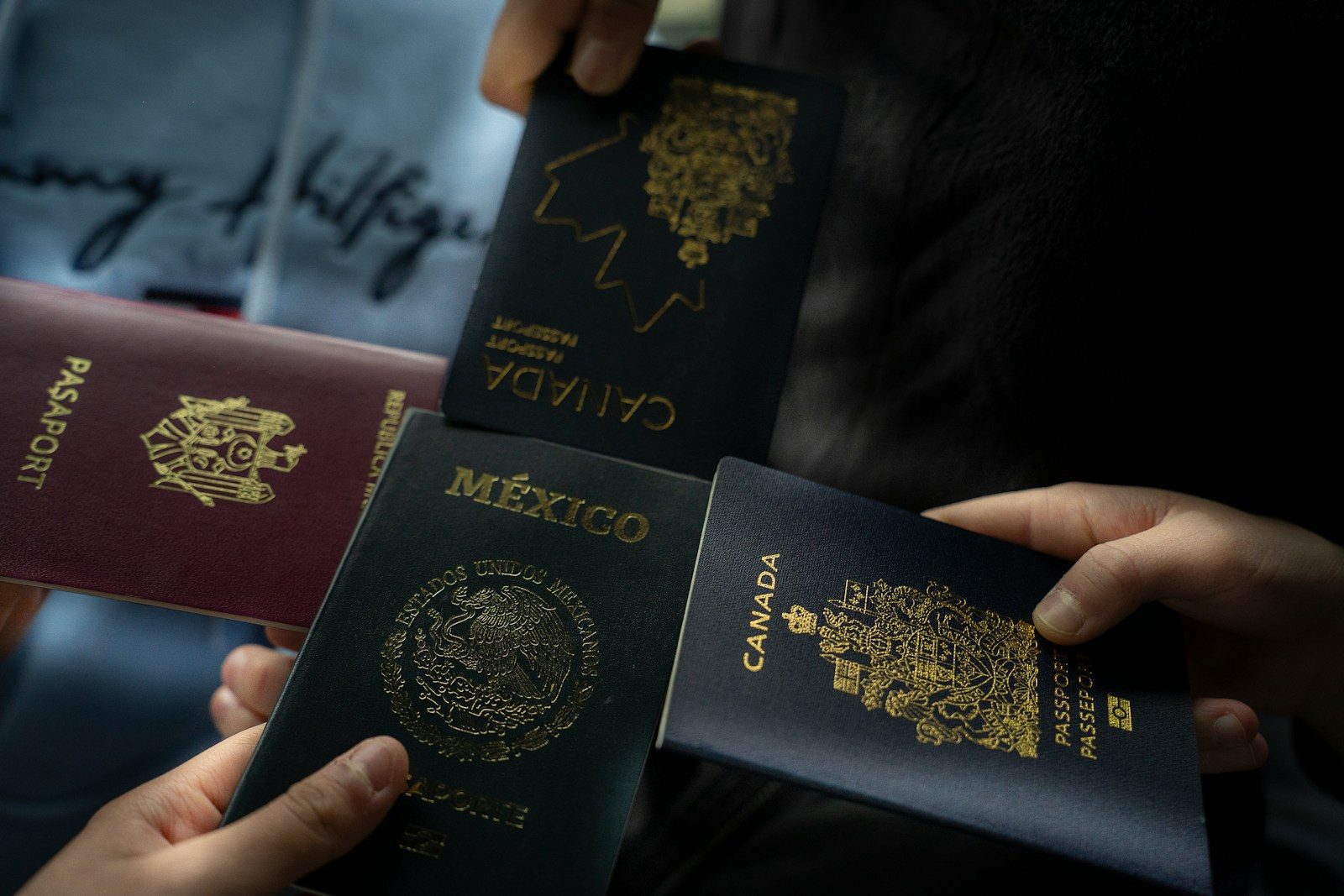 Four passports held by different people. Cross-border estate planning for international families with Wills and assets in multiple countries.